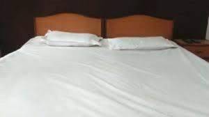 a white bed with two white pillows on it at Hotel YOGIRAJ LODGING BOARDIING,Deulgaon Raja 