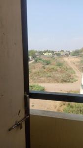 una porta con vista su un campo da una finestra di Hotel YOGIRAJ LODGING BOARDIING,Deulgaon Raja 