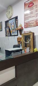 a desk with a clock on the wall and a table with a clock at Hotel YOGIRAJ LODGING BOARDIING,Deulgaon Raja 