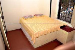 a small room with a bed in front of a window at Hotel YOGIRAJ LODGING BOARDIING,Deulgaon Raja 