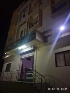 a building with a purple door and a balcony at Hotel YOGIRAJ LODGING BOARDIING,Deulgaon Raja 