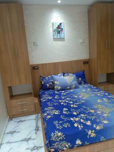a bedroom with a bed with a blue comforter at Aourir's new appartement in Agadir