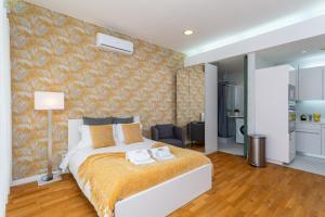 a bedroom with a large white bed and a living room at BeGuest Benfica Modern Flat in Lisbon