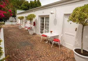 a patio with a table and chairs on a brick courtyard at Hotel du Vin Franschhoek in Franschhoek