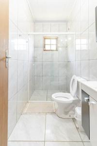 聖本圖－杜薩普卡伊的住宿－Chalé Vale do Coimbra，白色的浴室设有卫生间和水槽。