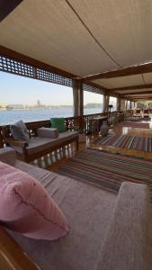 Zimmer mit einem Bett und Blick auf das Wasser in der Unterkunft Dahabeya Luxor Aswan in Luxor