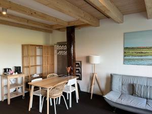 a living room with a table and a couch at Hotel Posthuys Vlieland in Oost-Vlieland