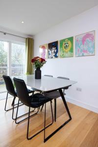a dining room table with chairs and a vase with flowers at Veeve - Here Comes the Sun in London