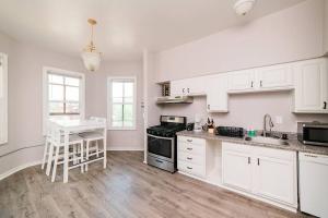 a kitchen with white cabinets and a table in it at Comfortable and Walkable - Off-Street Parking in Pittsburgh