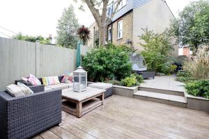 a small patio with a couch and a table at Veeve - Golds and Greens in London