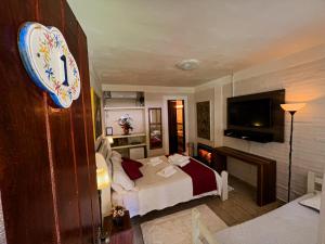 ein Hotelzimmer mit einem Bett und einem TV in der Unterkunft Espaço Viverde Penedo in Penedo