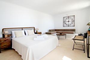 una camera da letto con un grande letto bianco e un divano di Villa Mezcal by Mykonos Mood a Mykonos Città Altre 44 foto