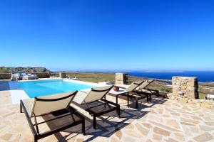 un gruppo di sedie sedute accanto a una piscina di Villa Mezcal by Mykonos Mood a Mykonos Città