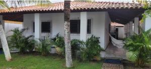 a white house with palm trees in front of it at Casa Catuçaba in Marechal Deodoro