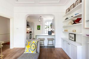 a kitchen with white walls and a table and a chair at Stunning Maida Vaile Apartment in London