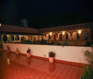 a courtyard with potted plants and a wall with lights at Mango Hill La Serene Puducherry in Pūrnānkuppam