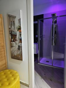 baño con ducha de cristal con iluminación púrpura en DREAM ROOMS, en Bagheria