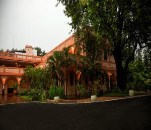 an orange building with a tree in front of it at Mango Hill La Serene Puducherry in Pūrnānkuppam