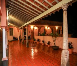 a lobby with a tile floor and columns and plants at Mango Hill La Serene Puducherry in Pūrnānkuppam
