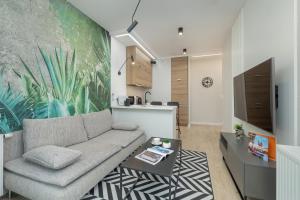a living room with a couch and a kitchen at Exclusive Apartment Rzeszów by Renters in Rzeszów