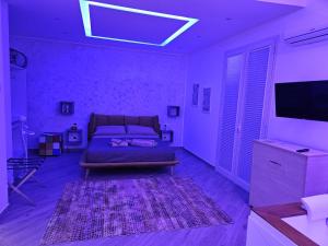 una camera con letto, TV e tappeto di DREAM ROOMS a Bagheria