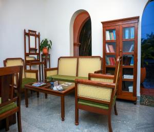 a room with chairs and tables and a book shelf at Mango Hill La Serene Puducherry in Pūrnānkuppam
