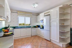 a kitchen with white cabinets and a window at Villa Pepe by Villa Plus in Es Mercadal