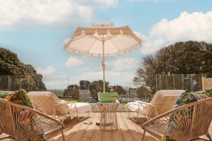 a patio with a table and chairs and an umbrella at The Nici in Bournemouth