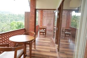 a room with tables and chairs on a balcony at WinterHome homestay in Munnar