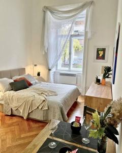 a bedroom with a bed and a window and a table at Robins Nest in The City Center in Maribor