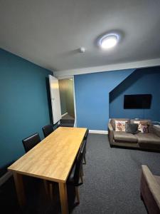 a conference room with a table and a couch at Spacious 5-Bedroom Urban Haven in Luton