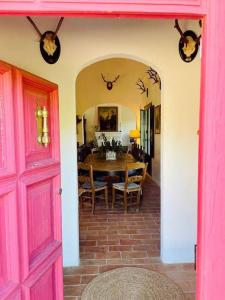 a dining room with a pink door and a table at Villa Lavanda by Época Suites in El Castillo de las Guardas