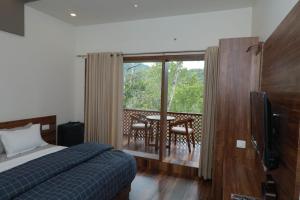 a bedroom with a bed and a balcony with a table at WinterHome homestay in Munnar