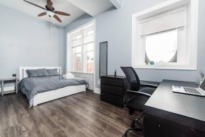 een slaapkamer met een bed en een bureau met een laptop bij Massive Home - GroupStay - Parking & Location in Pittsburgh