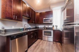 a kitchen with wooden cabinets and stainless steel appliances at Massive Home - GroupStay - Parking & Location in Pittsburgh