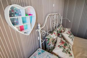 a bedroom with a heart shaped mirror and a bed at Apartament Trap in Karwia