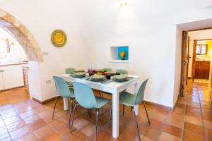 une salle à manger avec une table et des chaises blanches dans l'établissement Villa Trullo Lumise by Villa Plus, à Martina Franca