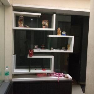 un estante en una habitación con algunas figuras en él en Luxurious 2BHK bunglow with garden, en Solapur