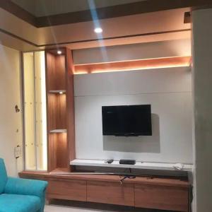 ein Wohnzimmer mit einem Flachbild-TV an der Wand in der Unterkunft Luxurious 2BHK bunglow with garden in Solapur