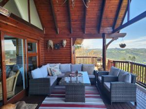 a porch with a couch and chairs on a deck at Knysna River View in Knysna