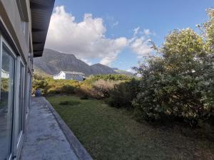 einen Blick auf ein Haus mit Bergen im Hintergrund in der Unterkunft Betty's Bay Cottage in Bettyʼs Bay