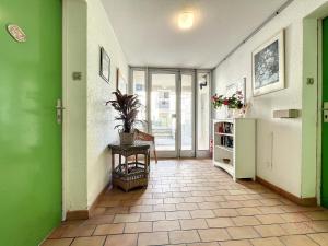 um corredor com paredes verdes e uma mesa com uma planta em Appartement Lamalou-les-Bains, 2 pièces, 2 personnes - FR-1-451-24 em Lamalou-les-Bains