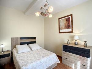 1 dormitorio con 1 cama y una foto en la pared en Appartement Lamalou-les-Bains, 2 pièces, 2 personnes - FR-1-451-37, en Lamalou-les-Bains