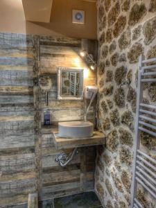 a bathroom with a sink and a stone wall at Ξενώνας Σαν Παραμύθι in Sinoikía Mési Trikálon