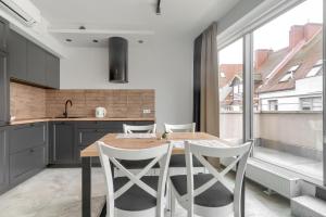 eine Küche mit einem Holztisch und weißen Stühlen in der Unterkunft Apartament Gran in Stettin