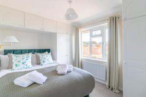 um quarto com uma cama com almofadas e uma janela em Breath Taking Sea View 2 bedroom Sleeps 6- Parking em Bournemouth