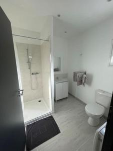 biała łazienka z prysznicem i toaletą w obiekcie Les Chalets du Mancel - Chalet Vakiry - 500 m Bouleries Jump , 10 min du circuit des 24h w mieście Parence