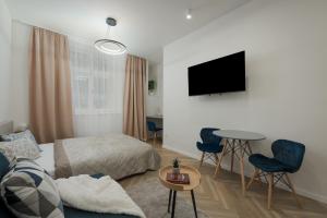 um quarto com uma cama, uma mesa e uma televisão em Hradešínská apartment em Praga
