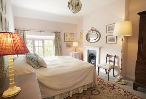 a bedroom with a bed and a lamp and a fireplace at Chanting Hill Farmhouse at Castle Howard in Welburn