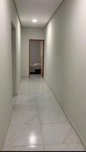 um corredor vazio com um quarto com uma cama em Casa préa kite em Cruz